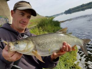 Un pêcheur au leurre tenant un aspe